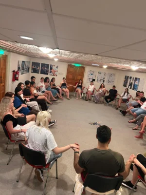 Participants forming a circle and engaging in a creative storytelling activity during the Citizens of Tomorrow youth exchange in Paphos.
