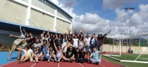 arge group of participants posing with raised hands during a team-building activity at the EU Teams for EU Dreams training course in Paphos.