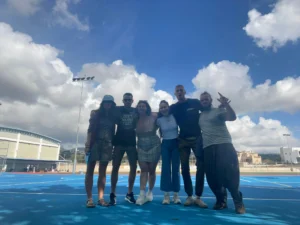 Small group of youth workers standing together on a blue sports court during the EU Teams for EU Dreams training course in Paphos, hosted by YETF.