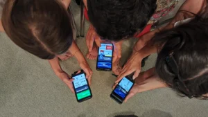 Participants using digital tools on their smartphones during a hands-on activity at the Into the Digital Erasmus+ training course.