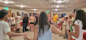Participants standing in a circle performing an interactive group exercise during the Into the Digital training course hosted by YETF.