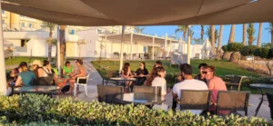 Participants discussing digital tools in small groups outdoors during the Into the Digital Erasmus+ training course hosted by YETF in Paphos.