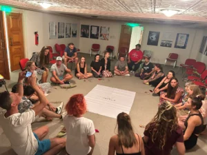 Participants sitting in a circle practising a well-being non-formal method during the A Journey to Well-Being Erasmus+ training course hosted by YETF in Paphos.