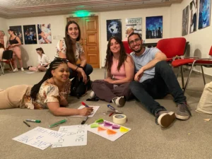Participants sitting on the floor creating posters during a creative leadership workshop at the Level Up Your Leadership Skills training course.