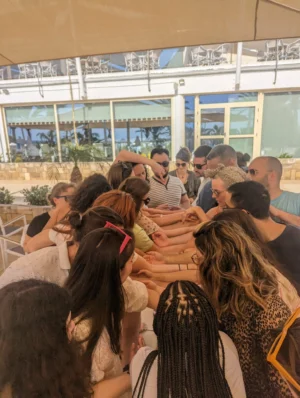 Youth workers participating in a collaborative hand-circle team-building exercise during the Level Up Your Leadership Skills training course in Paphos.