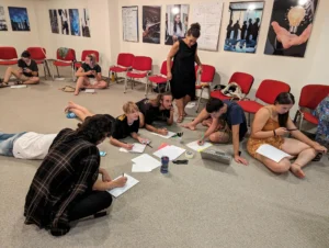 Participants collaborating on the floor during a project-planning workshop using non-formal education methods at the Make It Happen Erasmus+ training course.