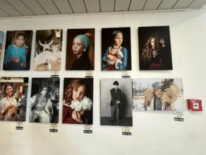 A wall displaying portrait photography from different cultures and styles, featured during the YETF photography training course.