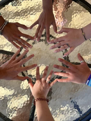 A circle of hands from participants forming a creative teamwork exercise during the YETF photography training course.
