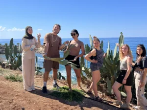 A group of youth workers posing outdoors near the sea during the YETF photography training course in Paphos.”